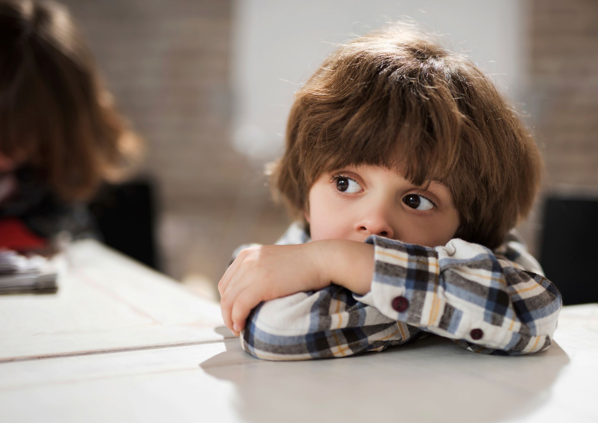 Look away boys. Sad children at School. Boy leaning on the Table. Boy leaning on Edge.